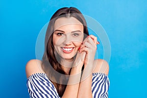 Photo of cute dreamy young woman dressed striped outfit smiling arms cheek isolated blue color background