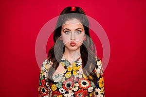 Photo of cute funky woman wear flower print dress bloated cheeks lips pouted plump isolated red color background