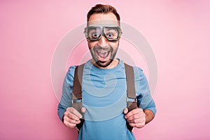 Photo of cute funny young guy wear blue pullover glasses arms backpack ready to skydive isolated pink color background