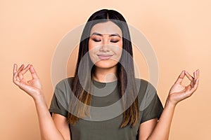 Photo of cute peaceful positive girl closed eyes hands fingers meditate yoga isolated on beige color background