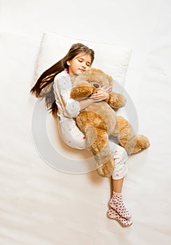 photo of cute sleeping girl hugging teddy bear