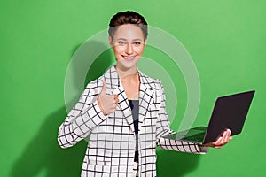 Photo of cute sweet woman dressed checkered clothes glasses holding gadget showing thumb up isolated green color