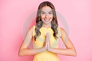 Photo of cute wavy hairdo young lady hands palms together plead toothy smile isolated on pink color background