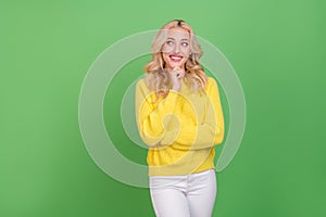 Photo of cute young blond lady look pomo wear yellow pullover isolated on green color background photo