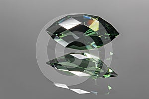 Photo of a dark green colored Prasiolite gemstone, cut in the shape of a Beginner marquise, with reflection in the mirror on which