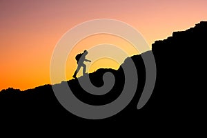 Photo in a dark key of a man climbing a mountain