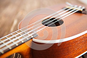 Photo depicts musical instrument ukulele guitar on a wooden