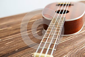 Photo depicts musical instrument ukulele guitar on a wooden