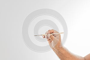 Photo detail of a hand holding a wooden brush on a white background