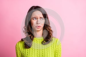 Photo of disgusted anxious girl grimace look side empty space wear green pullover isolated pink color background