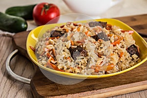 Photo of dish of uzbek pilaf made of rice and carrots, meat and onions