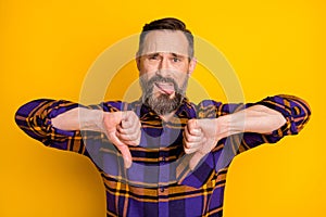 Photo of displease unhappy mature man make thumbs down dislike bad mood isolated on yellow color background