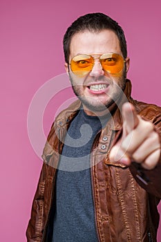 Photo of displeased man in orange glasses pointing forward