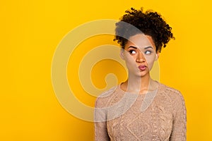 Photo of doubtful unsure lady dressed beige pullover looking empty space isolated yellow color background
