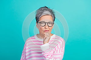 Photo of doubtful unsure woman dressed pink pullover eyewear hand arm chin empty space isolated teal color background