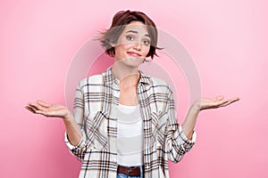 Photo of doubtful unsure woman dressed plaid shirt shrugging shoulders isolated pink color background