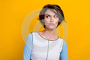 Photo of doubtful unsure woman wear top looking empty space isolated yellow color background