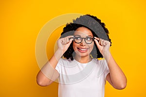 Photo of dream thoughtful lady dressed white t-shirt arms eyewear looking empty space isolated yellow color background