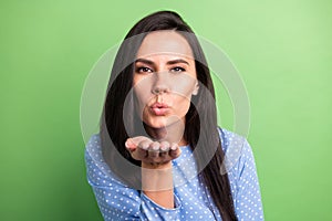 Photo of dreamy adorable young woman dressed blue outfit sending arm kiss isolated green color background