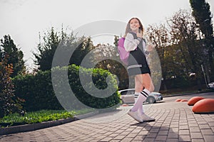 Photo of dreamy good mood girl dressed bomber short skirt backpack sending sms modern device outdoors urban city park