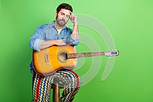 Photo of dreamy handsome guy wear denim jacket enjoy guitar music empty space isolated green color background