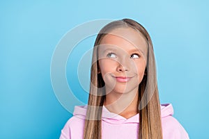 Photo of dreamy pretty young little girl look empty space imagine enjoy isolated on blue color background