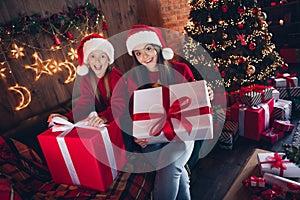 Photo of dreamy sweet little siblings dressed ugly print christmas sweaters open presents indoors house room