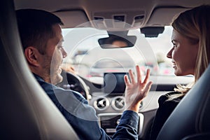 Photo of driver man and girl sitting in front seat of car.