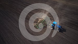 Photo from the drone of a tractor with seedbed cultivator ploughs field