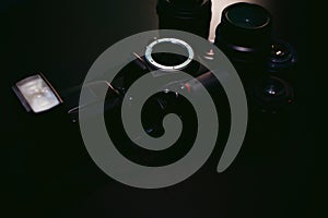 Photo DSLR camera with a set of retro lens and flash on a black background with wood texture