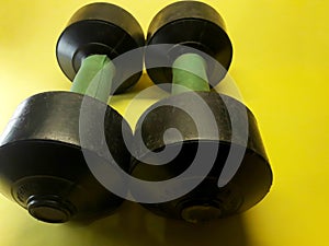 Photo of dumbbell hand muscle exercise equipment with a yellow background