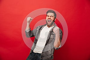 Photo of ecstatic cheerful man 30s in jeans jacket yelling in de