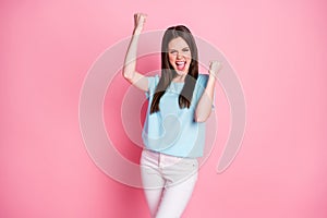 Photo of ecstatic girl win raise fists scream yeah isolated over pastel color background