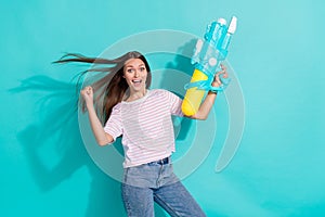 Photo of ecstatic impressed woman with straight hairstyle wear striped t-shirt hold water gun clench fist isolated on