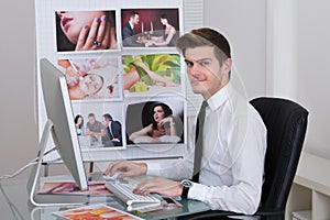 Photo editor using laptop at desk