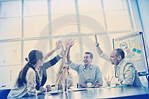 Photo editors high-five in meeting room