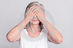 Photo of elderly woman happy positive smile hands cover eyese hide anonym isolated over grey color background