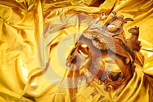 Photo of elegant and delicate Venetian mask over gold silk background