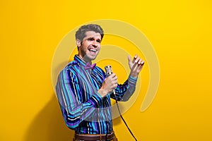 Photo of emotional man dressed striped shirt bow tie sing lyric song in microphone look empty space isolated on yellow