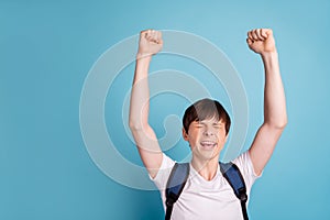 Photo of enjoying cheerful nice boy celebrating his victory at volleyball contests while isolated with blue background