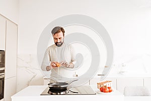 Photo of european man with short brown hair and beard cooking om