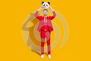 Photo of excited amazed entertainer guy hold panda head open mouth wear red suit tie isolated on yellow color background