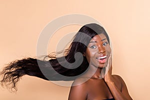 Photo of excited beautiful crazy lady open mouth hand cheekbone wind blow hair isolated beige background photo