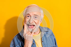 Photo of excited cheerful aged person fingers show heavy metal symbol isolated on yellow color background