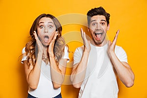 Photo of excited couple man and woman in basic clothing shouting