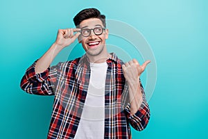 Photo of excited dreamy man dressed plaid shirt arm eyewear looking showing thumb empty space isolated turquoise color