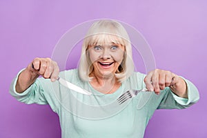 Photo of excited funky lady hold knife fork anticipate feast delicious food wear teal shirt isolated violet color