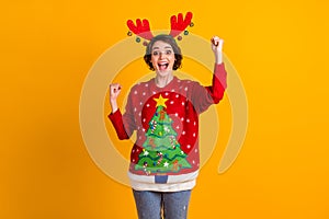 Photo of excited girl in christmas tree sweater pullover deer headband balls raise fists x-mas time noel lottery sale