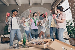 Photo of excited happy group of friends drink red cup toast celebrate party dormitory indoors inside house flat