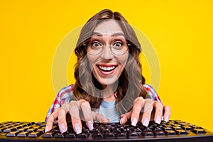 Photo of excited impressed girl with wavy hairdo dressed checkered shirt touch typing keyboard staring isolated on